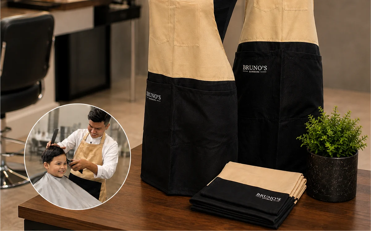 Branded aprons on display in a barbershop, with an inset photo of a barber wearing one
